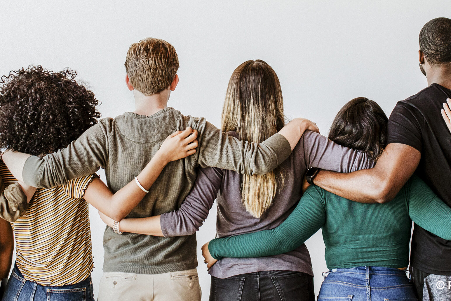 Chaîne humaine : 9 personnes se tiennent dans les bras, on voit l'arrière de leur tête et leur dos.