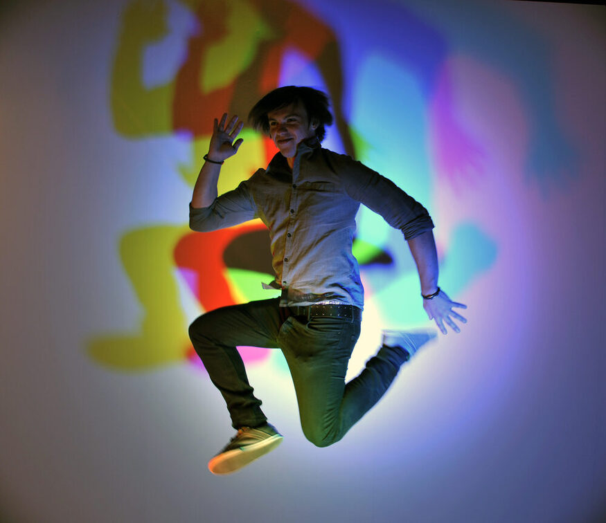 Відвідувач підстрибує в повітря, за ним - кольорові тіні