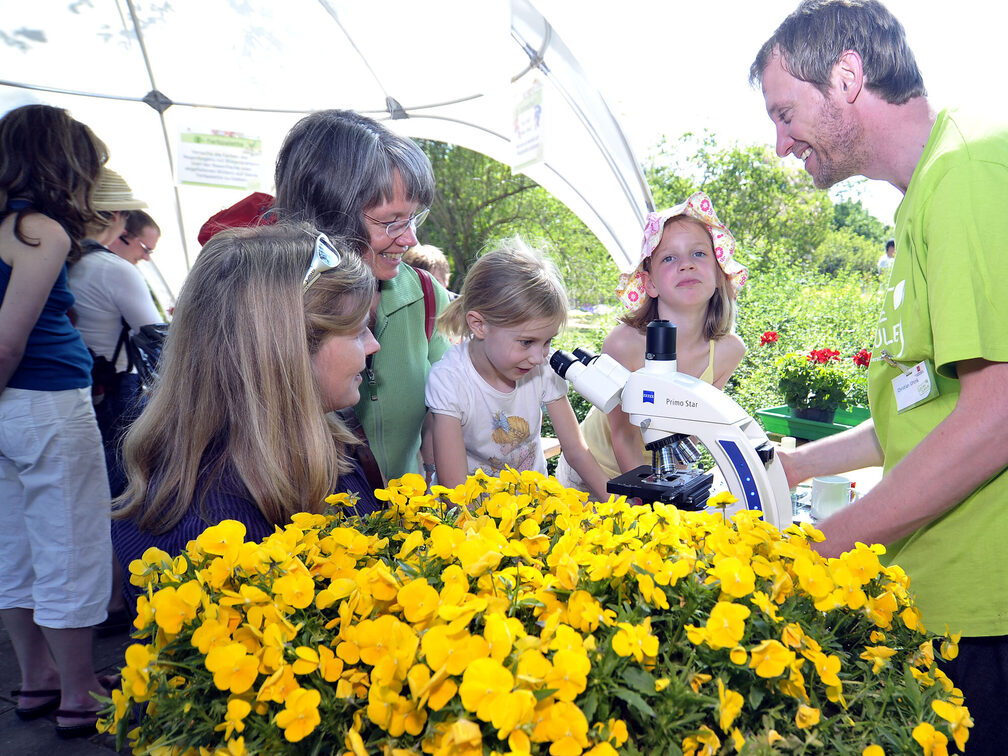 Молодий дослідник дивиться в мікроскоп