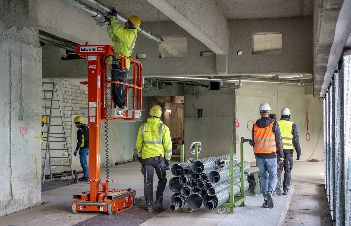 İnşaat işçileri belediye binasında çalışıyor.