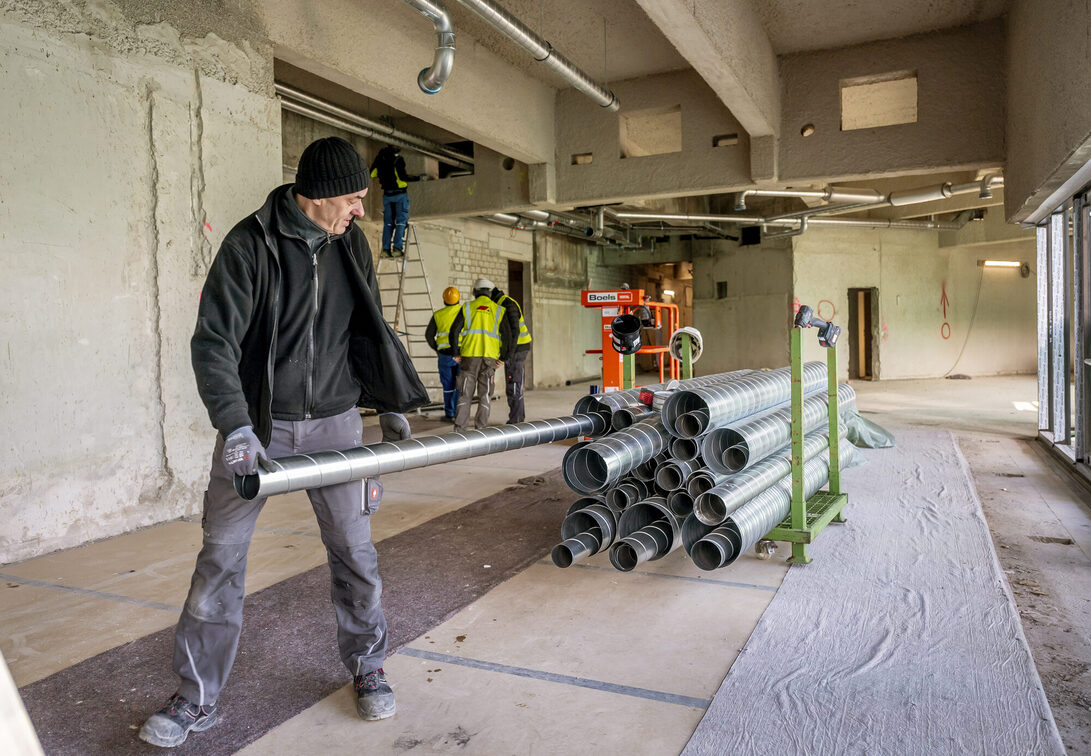 Borularla çalışan inşaat işçileri.