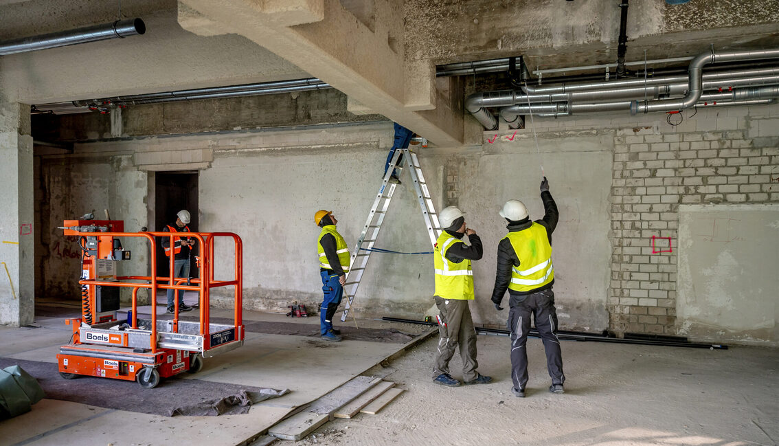 İnşaat işçileri belediye binasında çalışıyor.