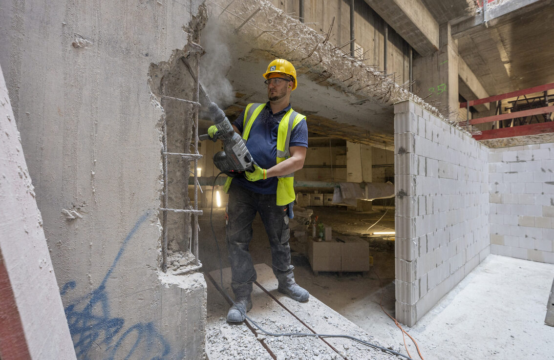 İnşaat işçisi betonu kaldırıyor.