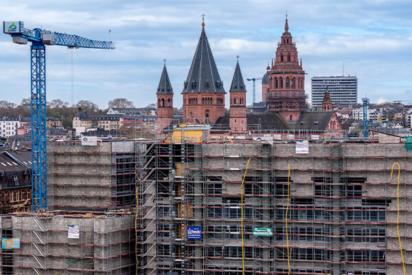 Ön planda vinç ve iskele ile belediye binası inşaat alanı, arka planda katedral.