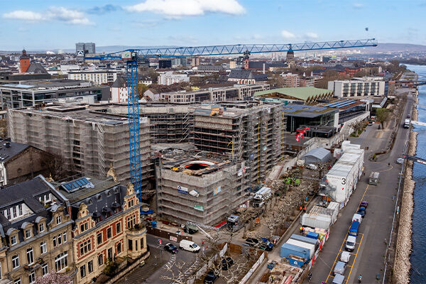 Vinçli belediye binası inşaat alanının drone görüntüsü, sağda konteynerler ve Ren Nehri kıyıları.