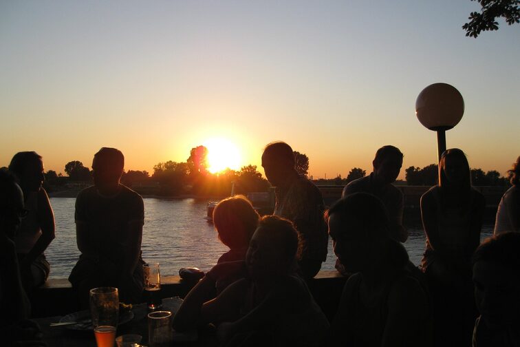Persone nella birreria all'aperto sulla riva del fiume