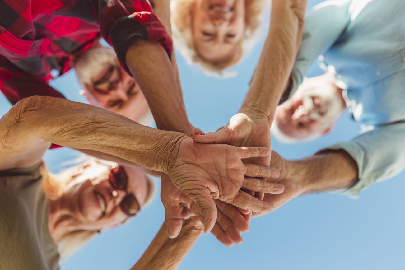 La photo montre des seniors se tenant la main